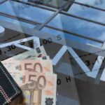 La scritta Bank con due banconote da 50 euro e dei documenti