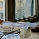 Notifica della Agenzia delle Entrate aperta davanti ad una finestra in giornata di pioggia