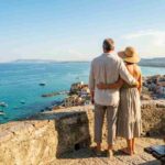 Un uomo e una donna in età pensionabile che ammirano il panorama marino